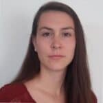 A woman with straight brown hair and light skin, wearing a maroon top, poses in front of a plain white background. Her neutral expression suggests new perspectives for 2025 as she looks directly at the camera.