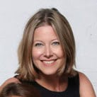 A woman with straight, shoulder-length blonde hair smiles at the camera. She is wearing a sleeveless black top, ready to discuss legacy devices in an upcoming webinar. The background is plain white.